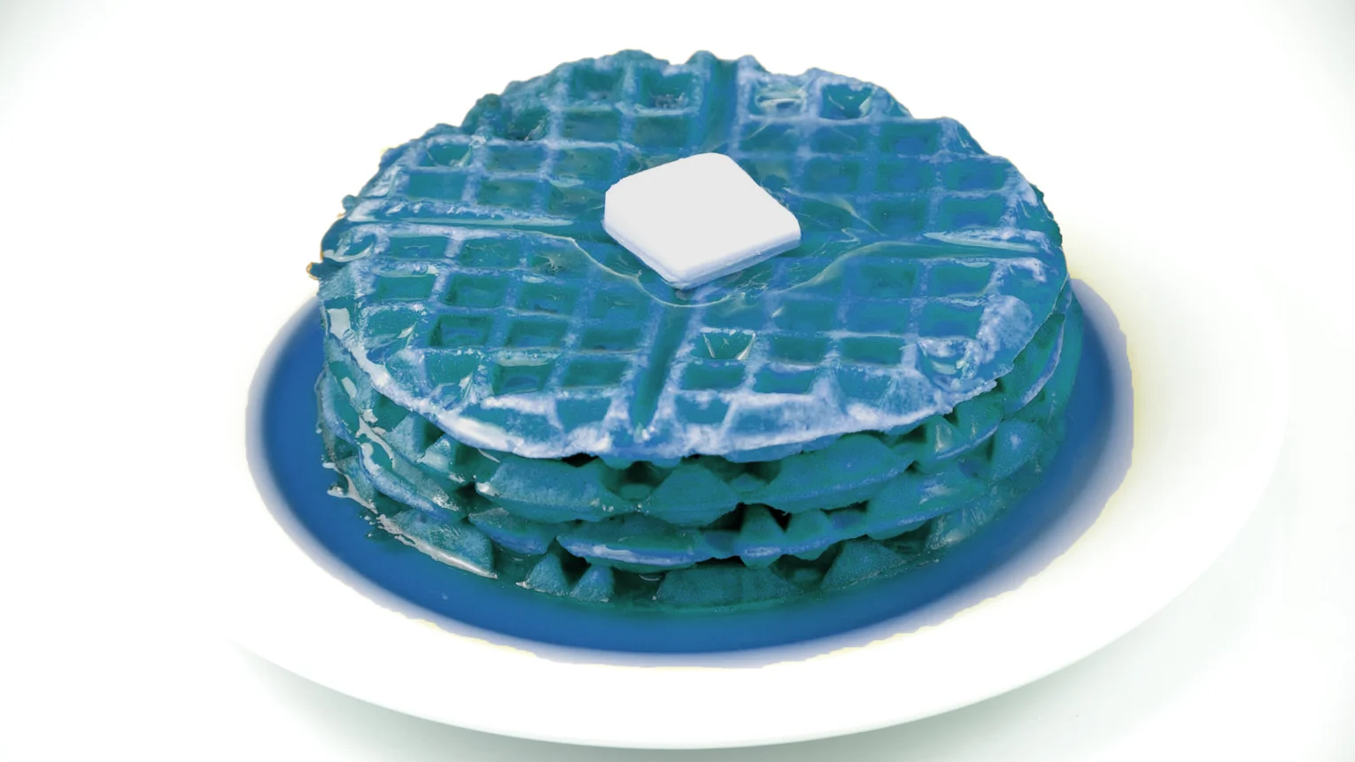 Stack of bright blue waffles with butter on a blue plate