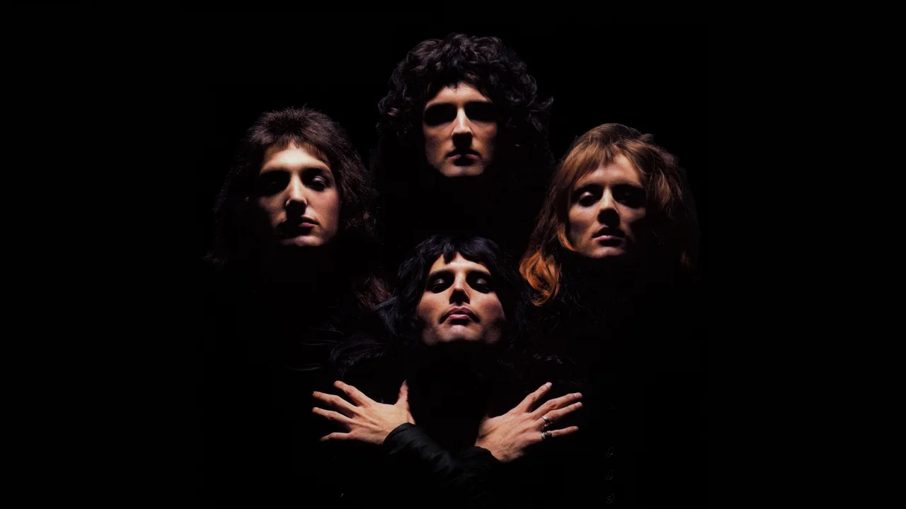 Queen band members in the iconic Bohemian Rhapsody diamond formation pose on a black background