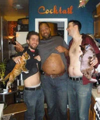 A humorous boozecats photoshop set in a 'Cocktail' bar with multiple men pictured with large cats digitally integrated, with visible 'Cocktail' signage.