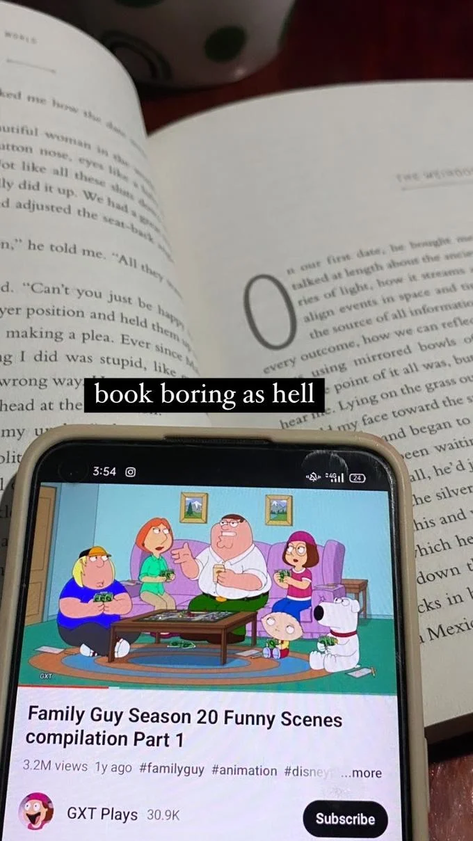 Boring Ahh Family Guy Episode — Open book with a phone playing a Family Guy Season 20 compilation, captioned 'book boring as hell'