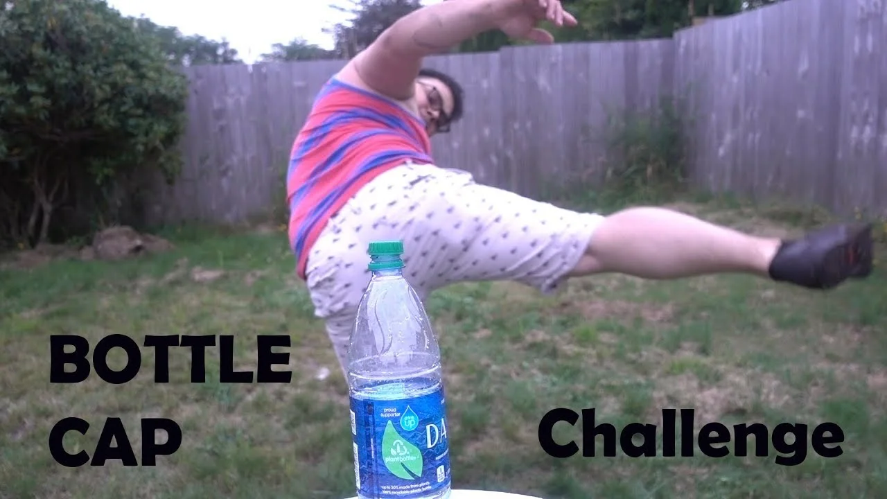 Bottle Cap Challenge — Person in striped shirt performing high leg kick for bottle cap.