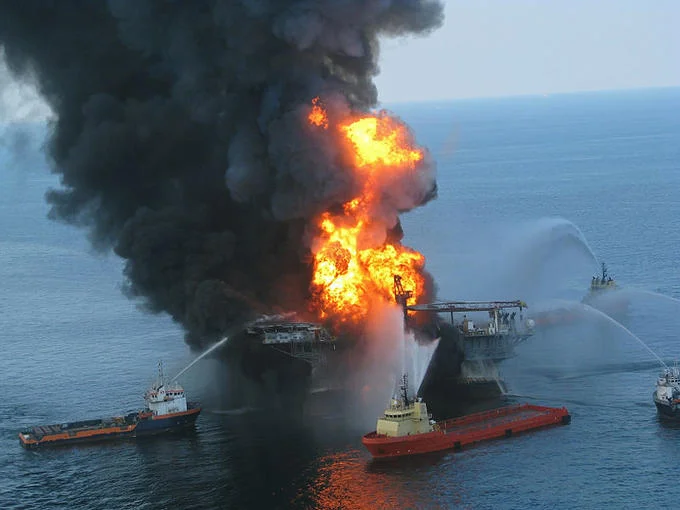 Bp Oil Spill — Deepwater Horizon oil rig on fire in the Gulf of Mexico with rescue boats spraying water