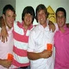 Bro — Casual snapshot of four young men standing together smiling at social gathering, dressed informally with personal photo appearance.