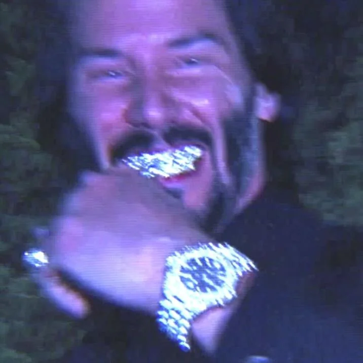 Bust Down Keanu — An AI-generated image of Keanu Reeves flexing a watch and grillz. The image was made by X user @TAKEOVERWW.