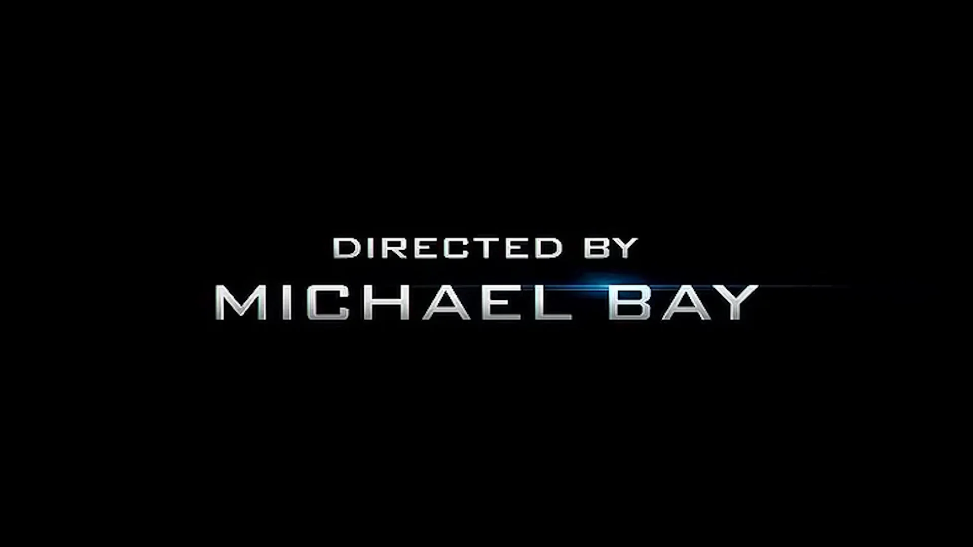 But It Came Out In 2007 Directed By Michael Bay — Silver 'Directed by Michael Bay' title card with lens flare on black background