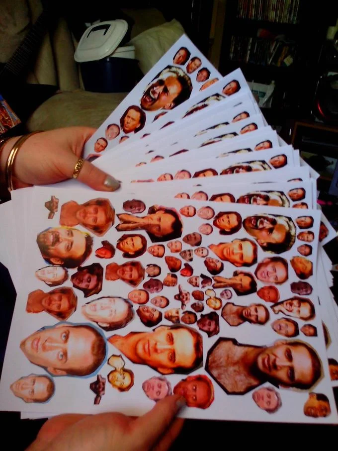 Caging — Printed sheets of many Nicolas Cage face cutouts held in a hand