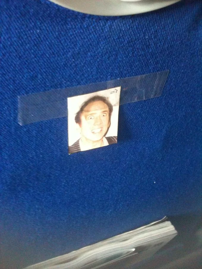 Caging — Small Nicolas Cage photo taped to a blue train seat back