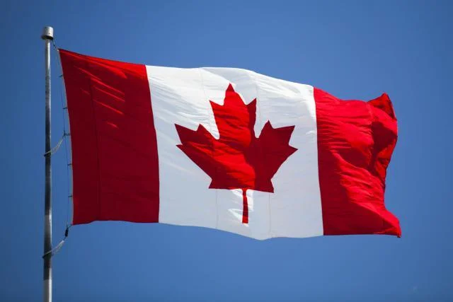 Canada — Canadian flag with red maple leaf against blue sky