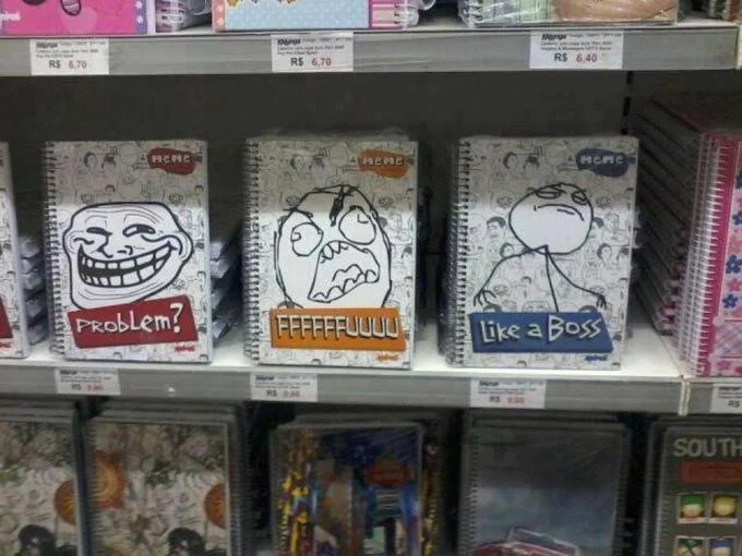 Cancer — Store shelf with notebooks featuring Trollface, rage guy, and Like a Boss meme covers