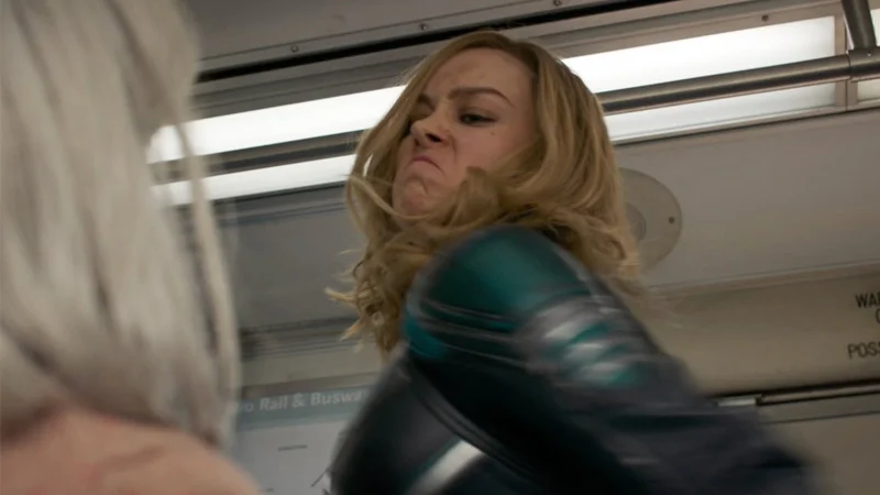 Captain Marvel punching an elderly woman on a bus, close-up mid-swing