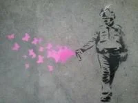 Casually Pepper Spray Everything Cop — A Banksy-inspired sidewalk stencil showing the pepper spray cop silhouette with pink butterflies from the canister.