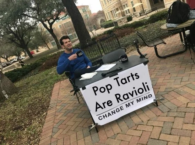 Steven Crowder at table with sign claiming Pop Tarts Are Ravioli CHANGE MY MIND.
