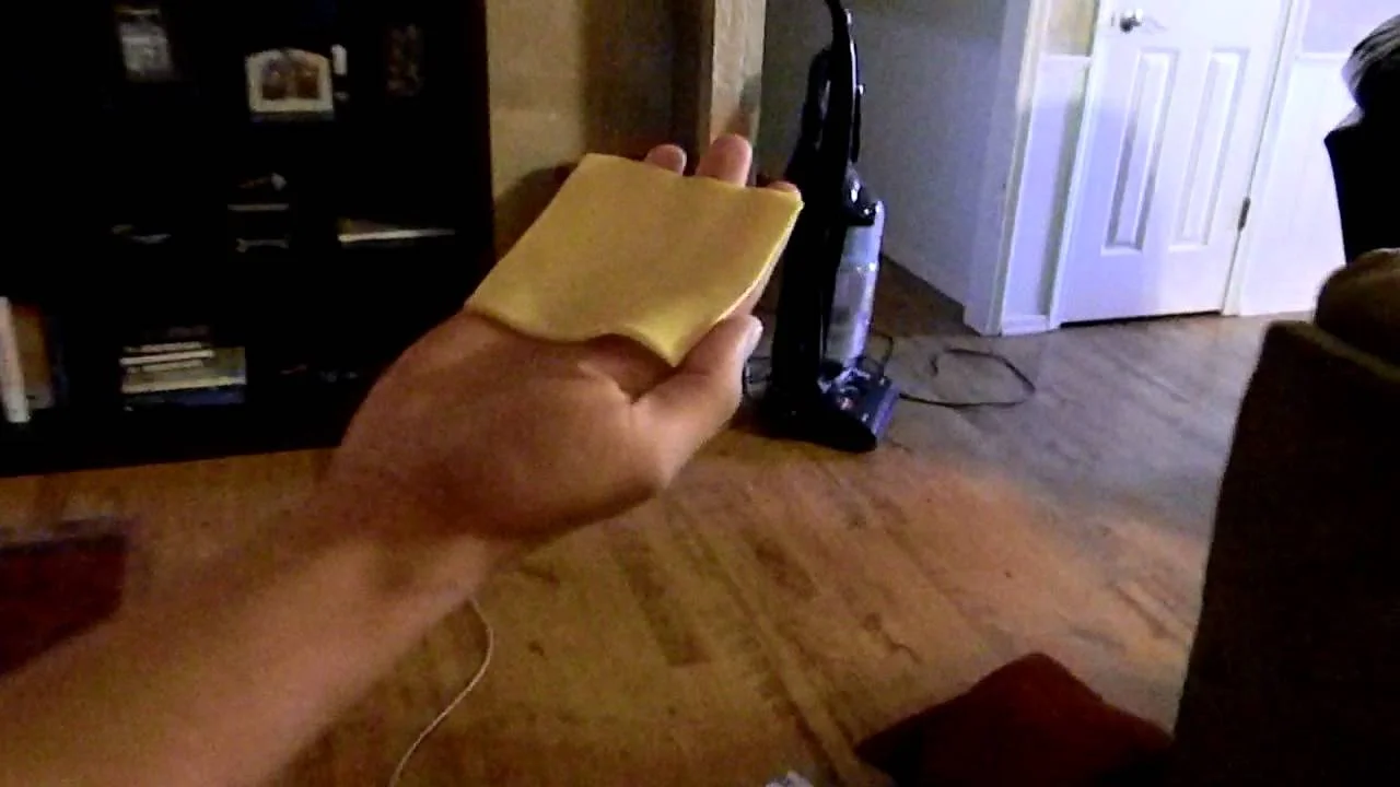Cheese Slap — Hand holding a slice of American cheese ready to throw in a living room