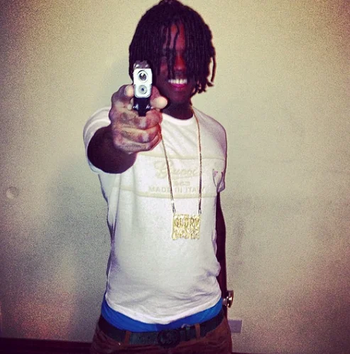 Chief Keef Almighty So 2 — Portrait photograph of Chief Keef pointing at camera in white sleeveless shirt and gold chain.