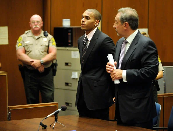 Rihanna — Chris Brown standing with attorney in courtroom