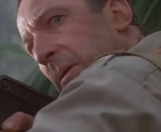 Robert Muldoon looking tense in the jungle from Jurassic Park's clever girl scene
