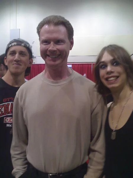 The Cockmongler subject posing with two fans at a convention