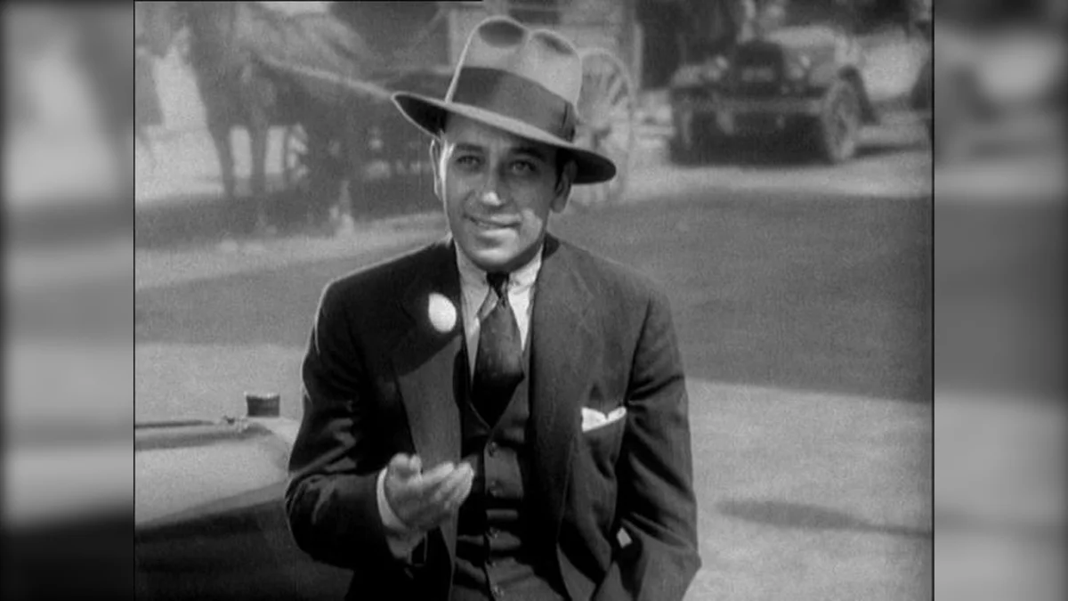 Coin Boys Story — Black-and-white film still of a man in a suit and fedora holding a coin