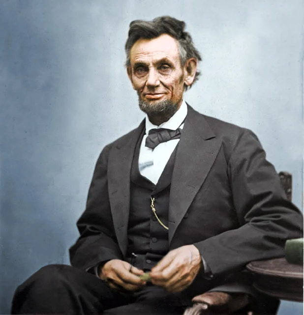 Colorized History — Colorized Abraham Lincoln portrait in dark suit with bow tie against bluish background.