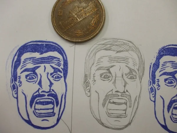 Commando — Handmade rubber stamp of Bennett's screaming face with a 500 yen coin