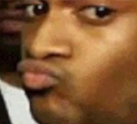 Conceited Reaction — Close-up of a man giving a skeptical side-eye with pursed lips.