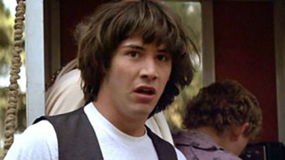 Keanu Reeves from Bill & Ted's Excellent Adventure displaying the skeptical, paranoid expression that became the Conspiracy Keanu meme.