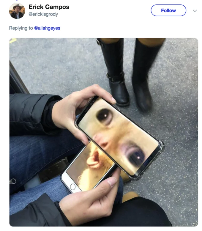Two phones held together displaying coughing cat face across their screens