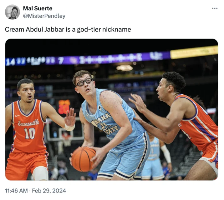 Cream Abdul Jabbar — Robbie Avila wearing goggles dribbles basketball while defended by two Evansville players during college game.