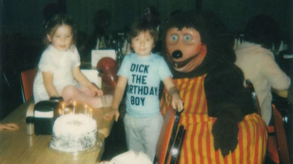 Cursed Images — Vintage birthday party photograph with children and adult in grotesque poorly-proportioned mascot costume with unsettling painted face.