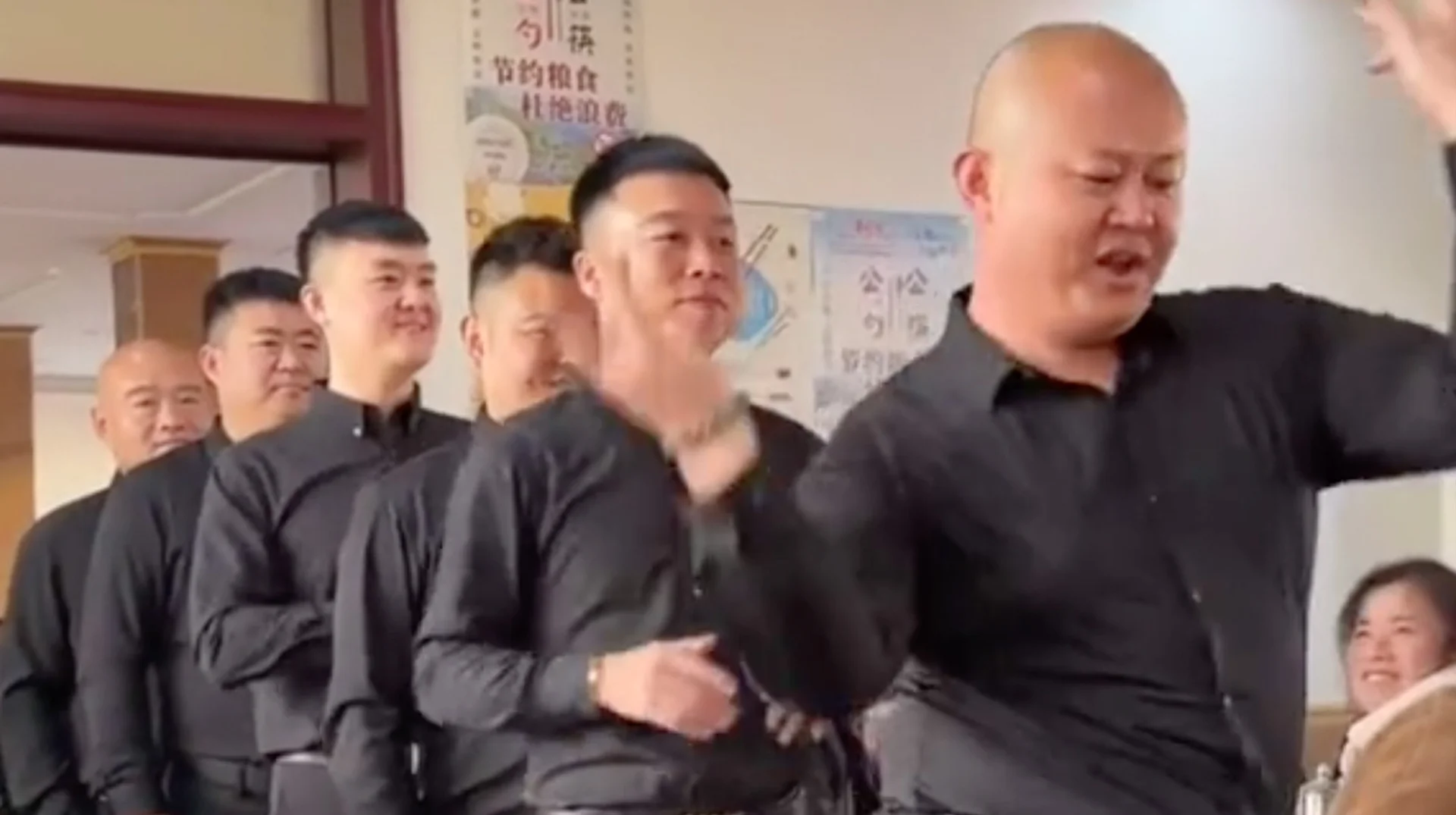 Dancing Chinese Waiters — Group of Chinese men in black shirts dancing in a line inside a restaurant