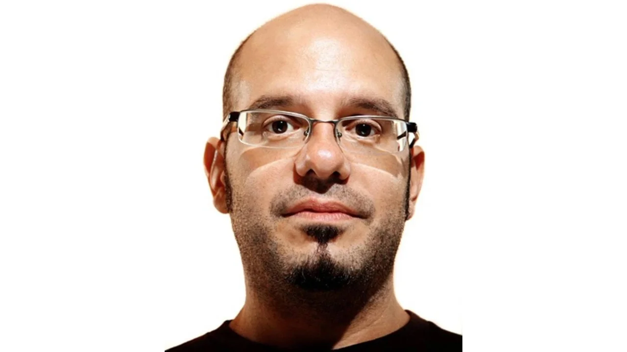 David Cross Stare — Bald bearded man with rimless glasses giving a blank, unamused stare at the camera
