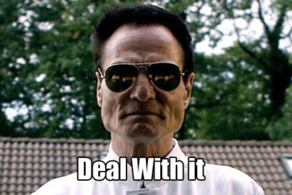 Man with round-framed sunglasses and calm expression against blurred background with 'Deal With it' caption.