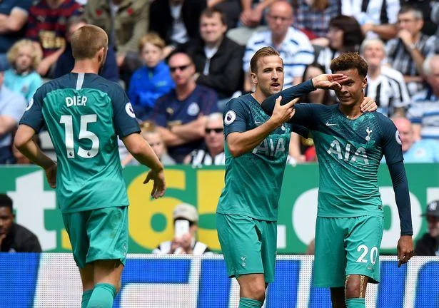Dele Alli Hand Celebration — Tottenham Hotspur players in teal kits celebrating on field during match with Dele Alli visible among team.