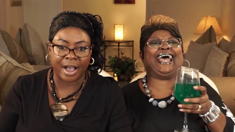 Diamond and Silk speaking to camera, one holding a green cocktail glass