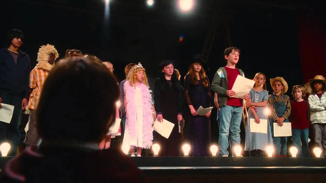 Diary of a Wimpy Kid "Total Eclipse of the Heart" — Children on stage in costumes holding sheet music during the school play scene from Diary of a Wimpy Kid