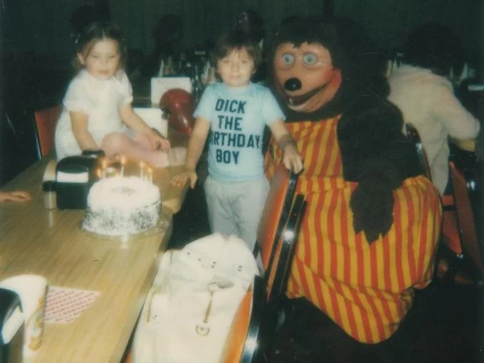 Dick The Birthday Boy — Full uncropped birthday party photo of Dick with the wide-eyed mascot and birthday cake on table