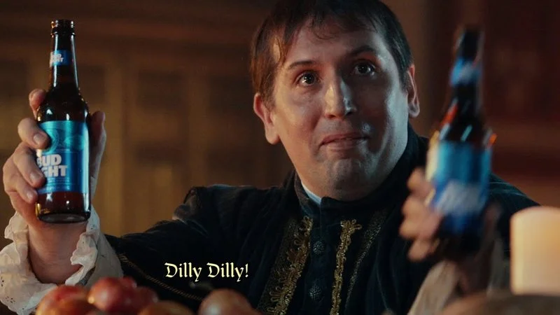 Iconic scene from Bud Light Dilly Dilly campaign showing medieval-dressed character enthusiastically holding Bud Light bottles.