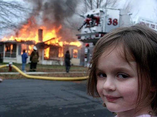 Disaster Girl — Original 2005 photograph with young Zoë Roth's characteristic smirk and burning house in background.