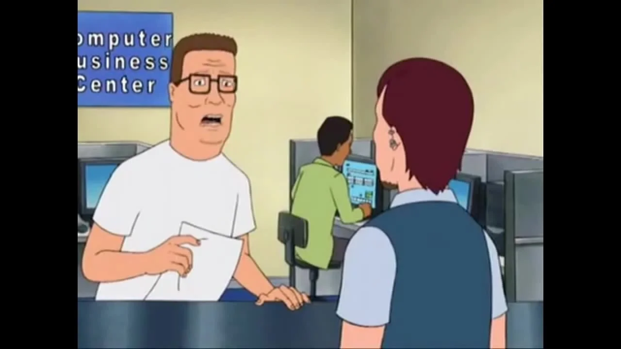 Do I Look Like I Know What A Jpeg Is — Hank Hill from King of the Hill at a Computer Business Center counter talking to a red-haired clerk