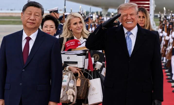 Donald Trump Flinches Beside Xi Jinping — Photo edit inserting a woman carrying MAGA hats and Trump luggage between Xi and Trump