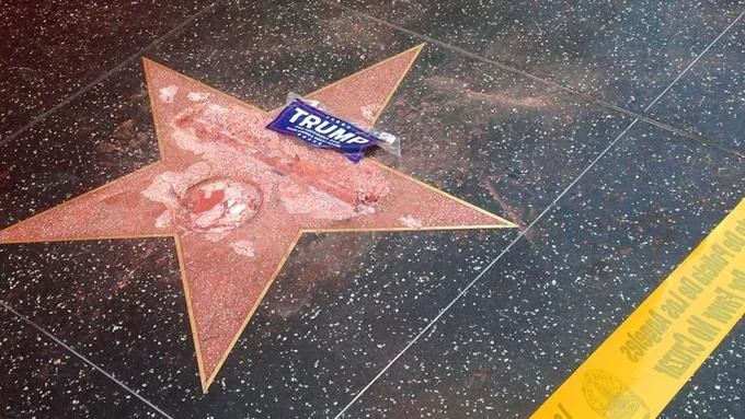Donald Trumps Hollywood Star — A close-up photograph of Donald Trump's pink terrazzo star on the Hollywood Walk of Fame with a blue 'TRUMP' sticker.
