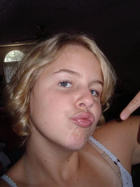 Duck Face — Blonde teenage girl taking a selfie with an exaggerated duck-face pout