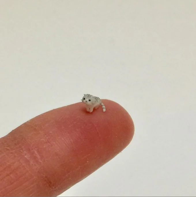 El Wiwi — Miniature gray tabby cat figurine on a fingertip, uncropped version