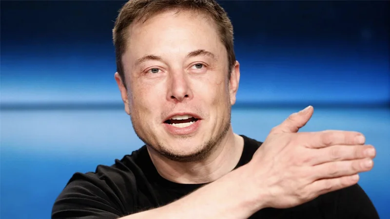 Elon Musk speaking and gesturing at a press conference
