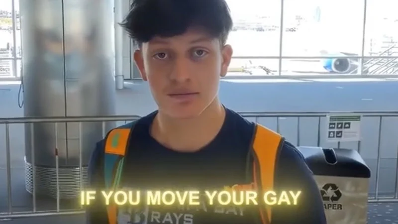 English Or Spanish — Person in orange and black safety vest standing frozen with 'IF YOU MOVE YOUR GAY' text.