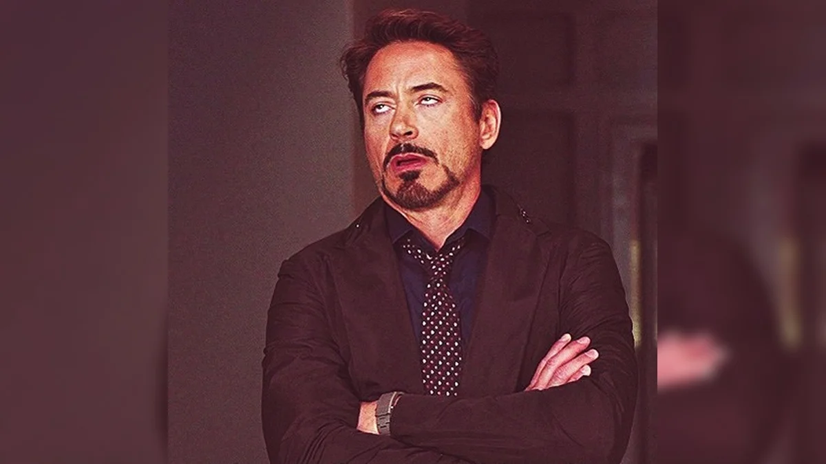 Eye Rolling Robert Downey Jr — Robert Downey Jr. rolling his eyes with arms crossed in a black jacket.