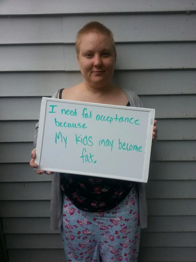 Fat Acceptance Movement — Woman holding whiteboard fat acceptance sign about her children