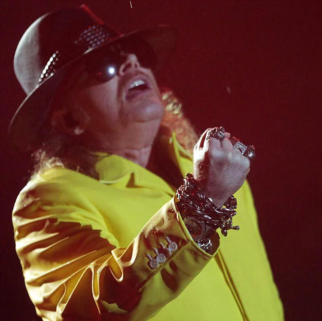 Fat Axl Rose — Axl Rose in yellow jacket and hat singing on stage