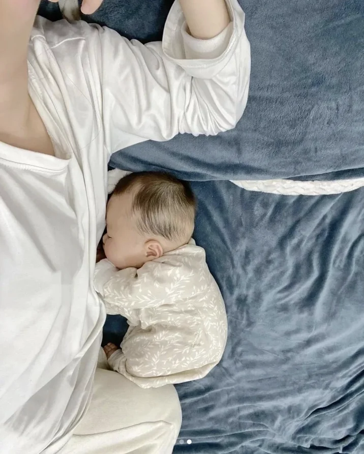 Fat Chinese Baby — Baby in leaf-print onesie resting against adult in white