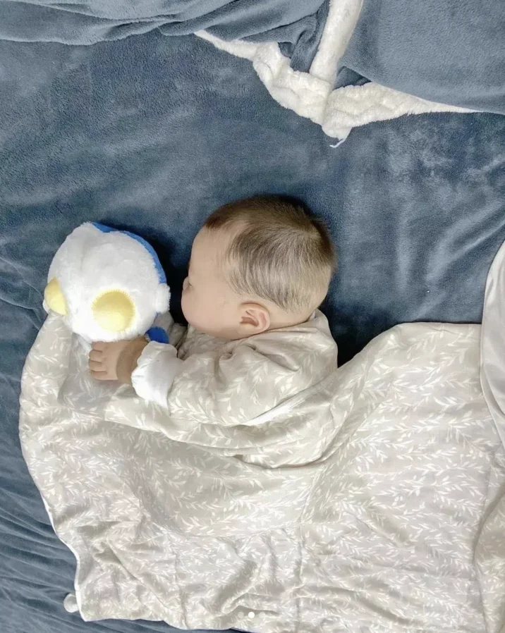 Fat Chinese Baby — Baby sleeping next to a Piplup plush toy on blue blanket
